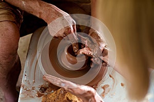 The potter is molding from clay on a potter`s wheel. The hands of the potter