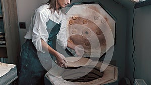 Potter preparing the pottery kiln for the baking process for her dish