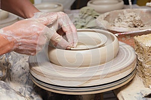 Potter's hand shaping clay tray