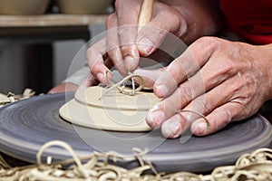 Potter's hands carving groove