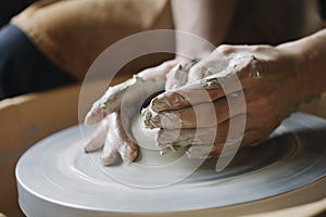 Potter`s hands making clay bowl on pottery wheel