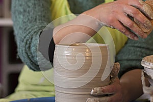 Potter`s hands making a clay pot on pottery