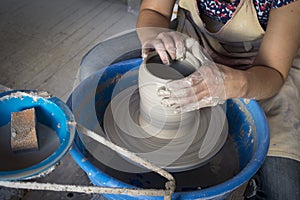 Potter`s hands making a clay pot on pottery