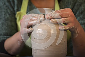 Potter`s hands making a clay pot on pottery