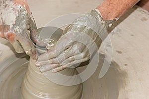 Potter`s hands in making earthen pot