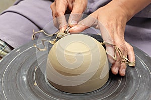 Potter's hands milling clay bowl photo