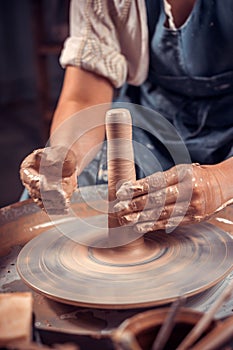 Potter`s hands and potter`s wheel. Close-up.