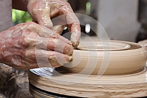 Potter's hands shaping bowl