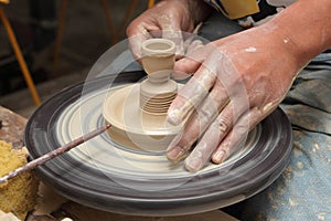 Potter's hands shaping candlestick