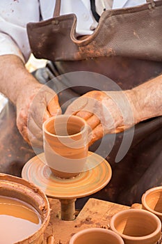 Potter`s hands shaping up the clay