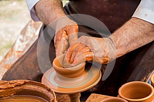 Potter`s hands shaping up the clay