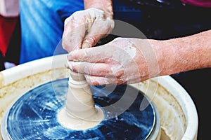 Potter`s hands skillfully form a jug on a potter`s wheel_