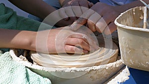 Potter`s hands work with clay on a potter`s wheel