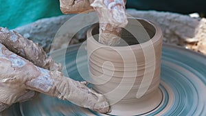 Potter`s hands work with clay on a potter`s wheel. slow motion