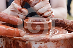 On the potter`s wheel revolve a clay cup.