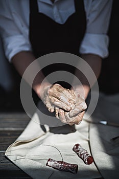 The potter`s woman hands are shaping a cup from a clay. The process of creating pottery. The master ceramist works in