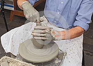 Potter shaping clay on a potter's wheel