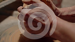 Potter shaping a raw clay on rotating wheel. Skilled craftsman showing masterclass molding ceramic product in workshop