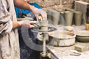 Potter teaches to sculpt in clay pot on turning pottery wheel photo