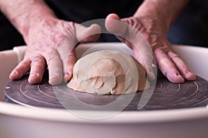 Potter wheel and hands of craftsman making a jug