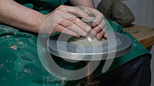 Potter at work. Hands of potter do a clay pot