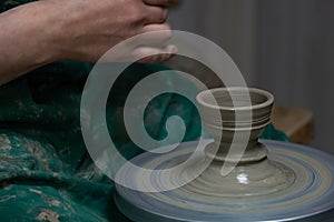 Potter at work. Hands of potter do a clay pot