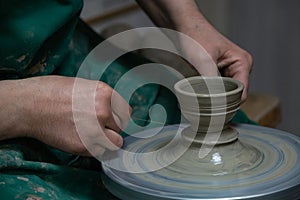 Potter at work. Hands of potter do a clay pot