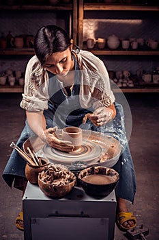 The potter works in the workshop. Hands and a potter`s wheel close-up.