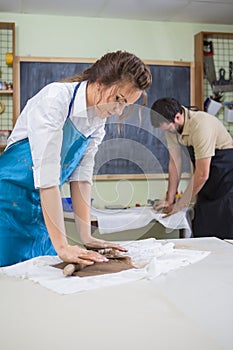 Pottering and Clay Making Process Concepts. Two Professional Clay Makers During a Process of Clay Preparation on Tables in