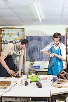 Pottering Process Concept. Two Professional Ceramists or Claymakers During a Process of Clay Preparation on Tables in Workshop