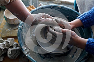 Potters courses. the master guides the disciple. hands of a potter and his ward