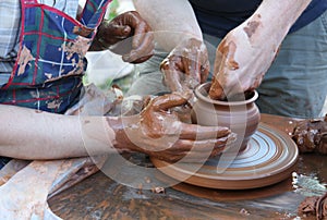 Potters hands creating a clay pot photo