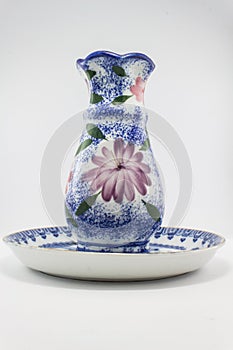 Pottery ceramic jug on plate isolated background