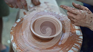 Pottery class and workshop a professional male potter works with a woman and shows how to make pottery in a pottery