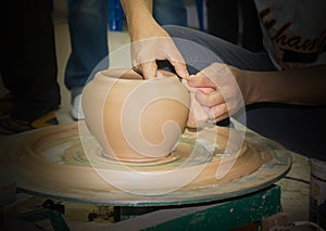 Pottery clay vase being formed and modeller hands