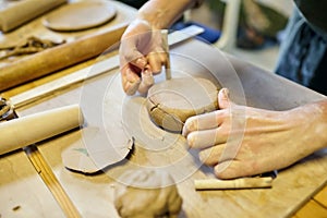 Pottery. A girl with a string in her hands and clod clay