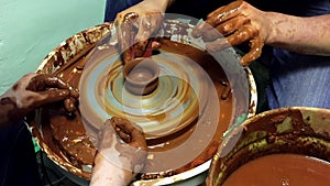 Pottery hands creating an earthen jar on a spin wheel