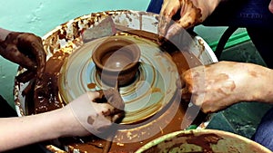 Pottery hands creating an earthen jar on a spin wheel