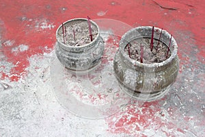 Pottery with incense sticks at a weathered table, Buddhism in China photo