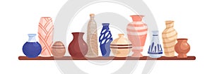 Pottery objects on shelf. Ceramic and porcelain flower vases, clay pots, and earthen vessels composition. Crockery and