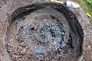 Hidden pottery pieces inside earthen chamber of primitive pit fire kiln photo