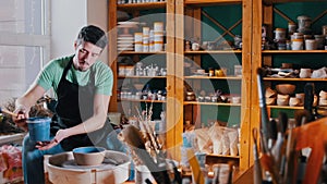 Pottery - the potter`s master is sitting in his workshop among his tools