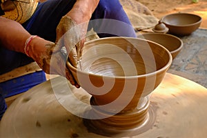 Pottery - skilled wet hands of potter shaping the clay on potter wheel