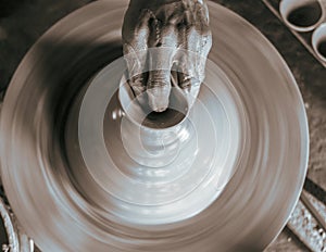Pottery wheel with potter`s hands .