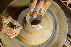 Pottery wheel with potter`s hands .