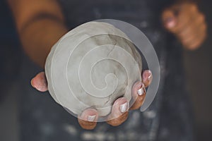 Pottery woman shows white clay, potter`s hands