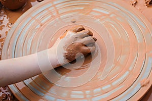 Pottery workshop outside. Master teaching kid to creating on the pottery wheel