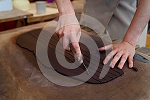 pottery workshop working raw ceramic vase and clay to make pot. Pottery workshop with natural light scraping, smoothing,