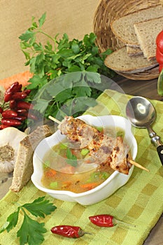 Poultry consomme with chicken skewers