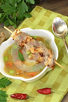 Poultry consomme soup with green and bread